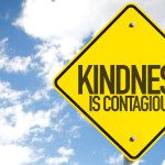 Kindness Is Contagious sign with sky background
